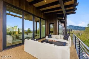 Expansive outdoor patio with wood-slat ceiling, exposed beams, and a built-in linear fire pit