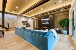 Wood-finish flooring, accent wall with integrated linear fireplace, and ceiling with recessed lighting