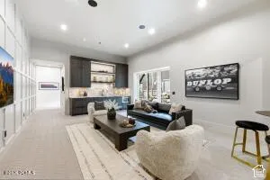 Recessed lighting, built-in cabinetry with under-cabinet lighting, wood-finish coffee table, and light-toned flooring