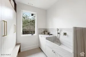 Built-in tiled utility sink with wall-mounted faucet and handheld sprayer