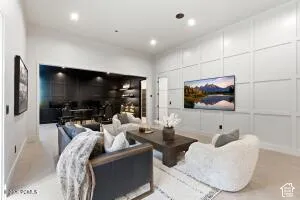Recessed lighting, light-colored flooring, accent wall with paneling, built-in shelving, dark-toned wall