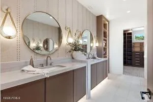 Dual basin vanity with white countertops, wall-mounted oval mirrors, and integrated shelving