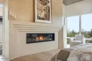 Linear fireplace with a stone surround, large windows, and vaulted ceilings