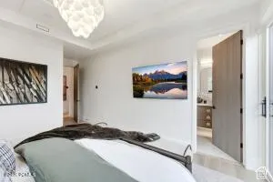 Recessed ceiling, tray ceiling detail, wood-finish flooring, contemporary light fixture, solid core door