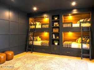 Built-in bunk beds with integrated shelving, wood-finish paneling, recessed lighting, and panel wall accent