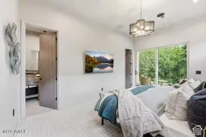 Vaulted ceiling with a contemporary chandelier, large glass sliding doors, and light-colored flooring