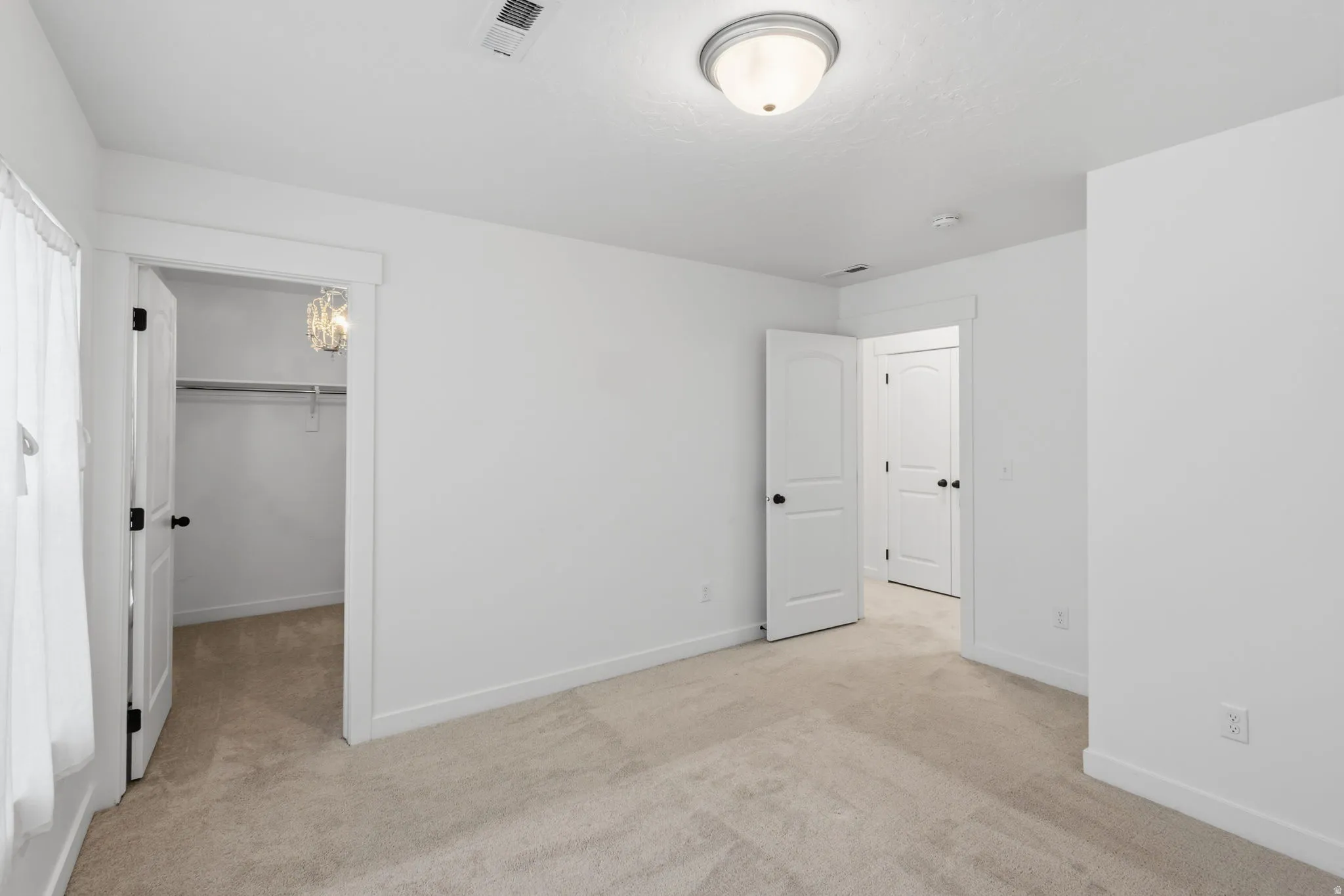 Carpeted room with white walls, baseboards, and trim