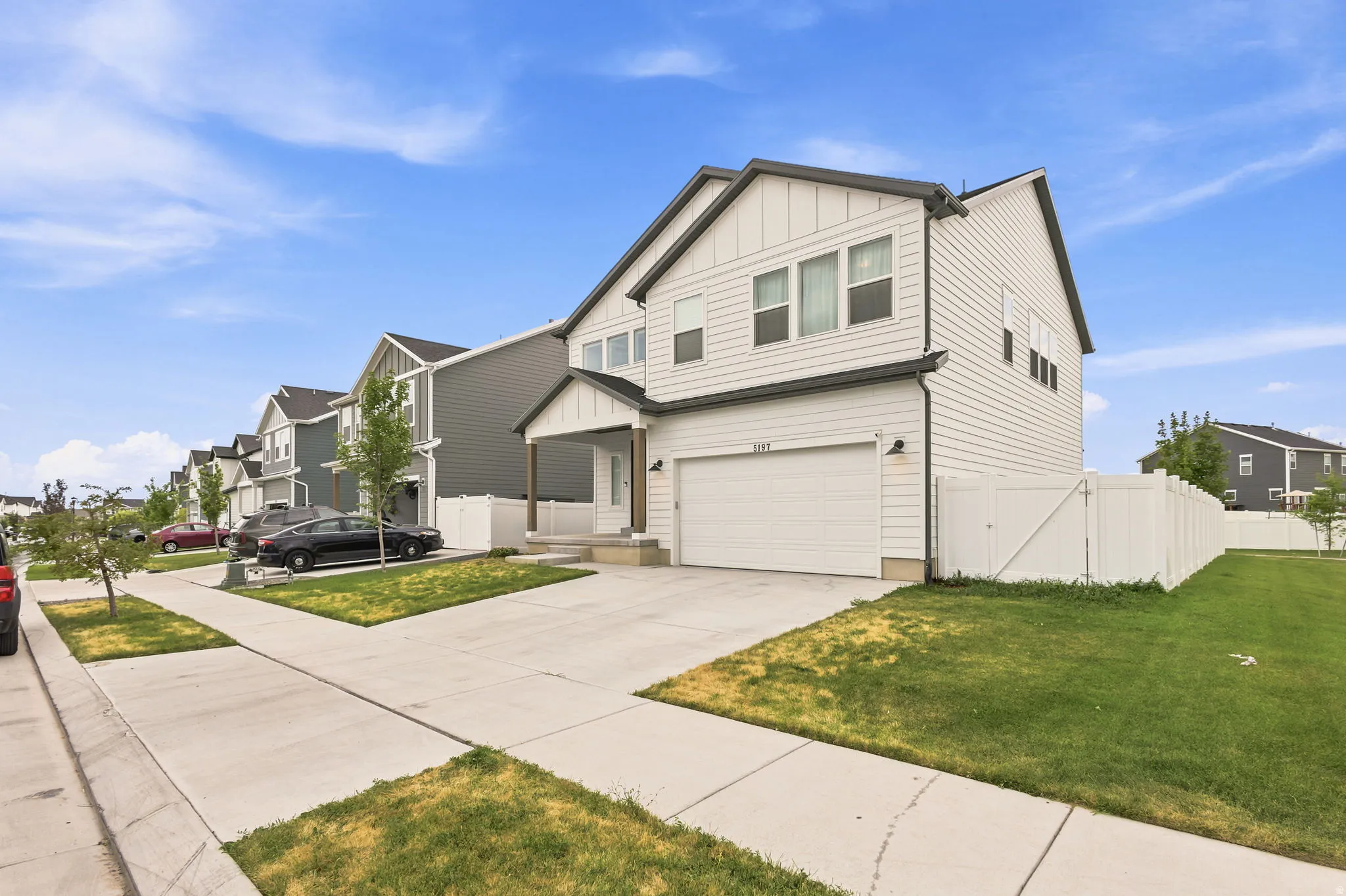 Two-story residence featuring light-colored siding with dark trim accents