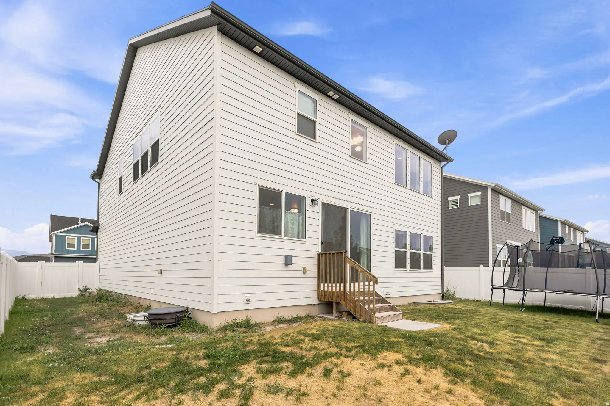 Two-story residence featuring white horizontal siding and a dark gray roofline