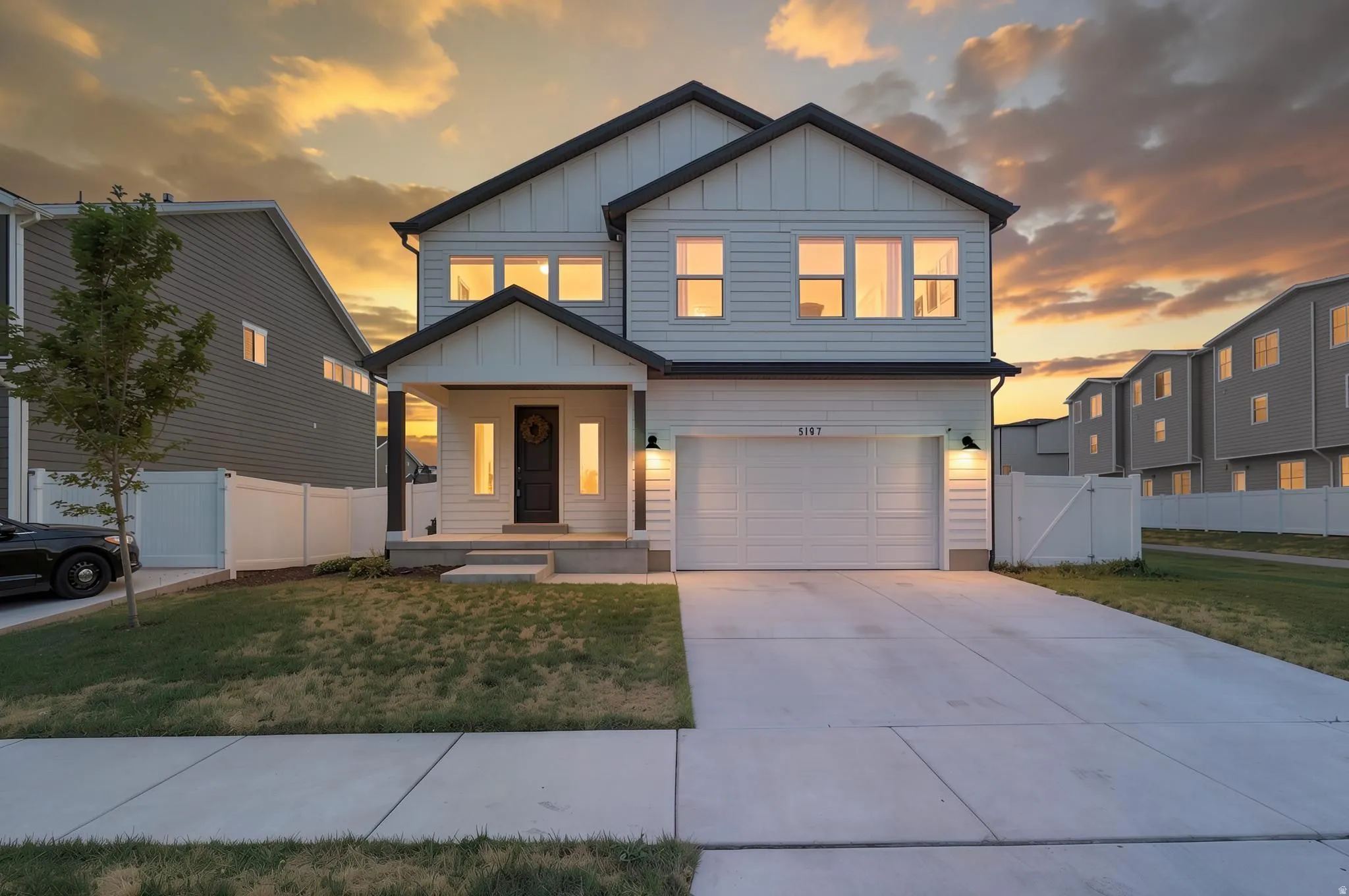 Contemporary two-story residence featuring light-toned horizontal siding and dark trim accents