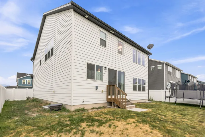 Two-story residence featuring white horizontal siding and a dark gray roofline