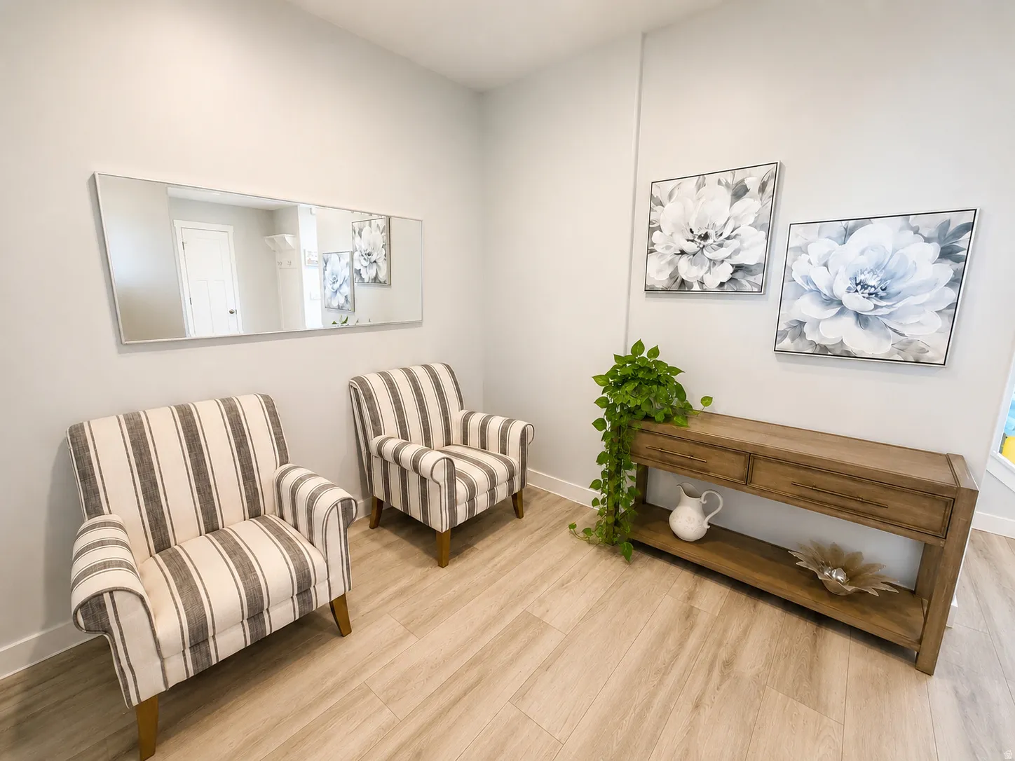 Light-toned wood-finish flooring complements the neutral wall color