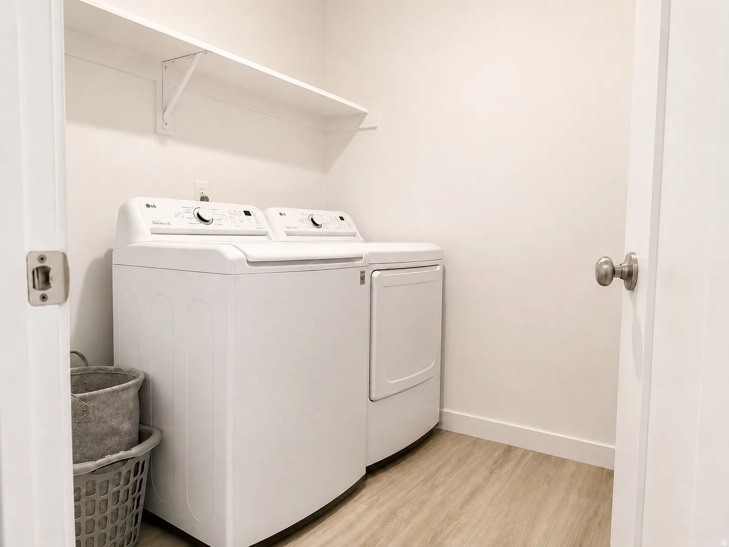 White walls, wood-finish flooring, and an integrated white shelf