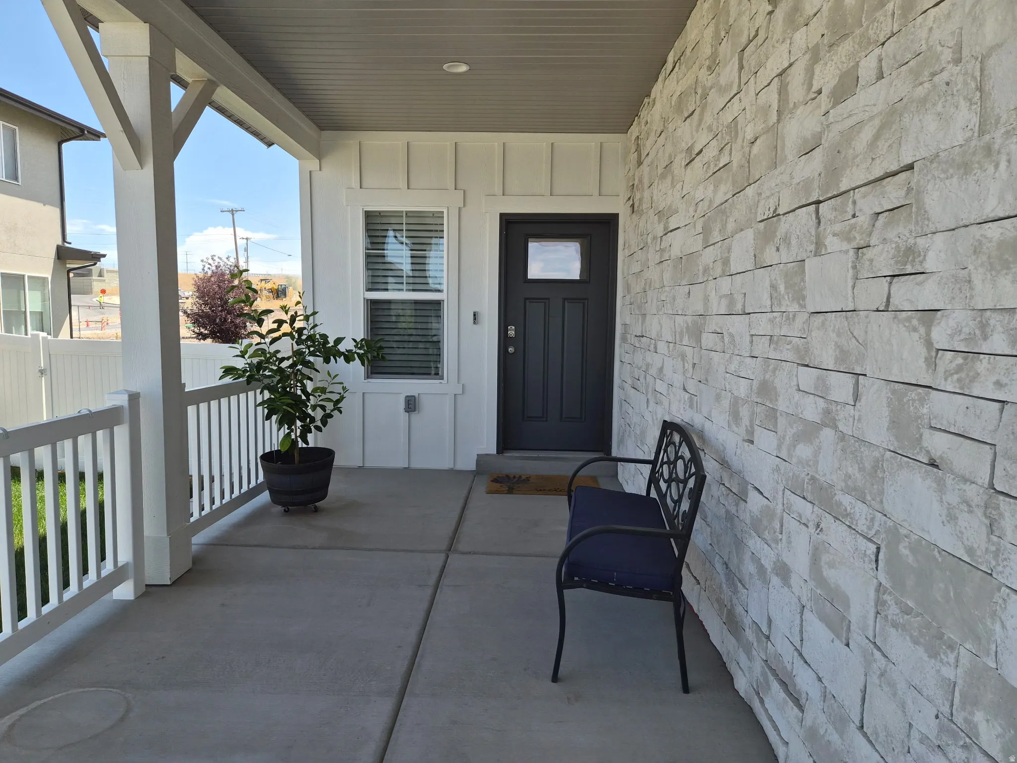Covered porch with concrete flooring and white railing
