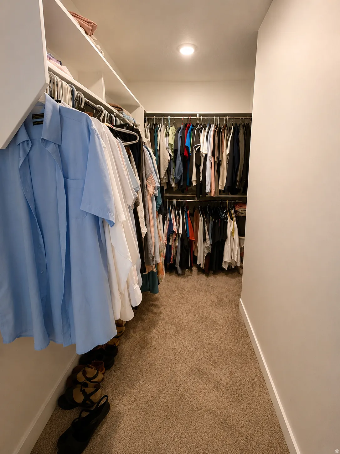 Walk-in closet featuring built-in shelving, multiple hanging rods, and recessed lighting