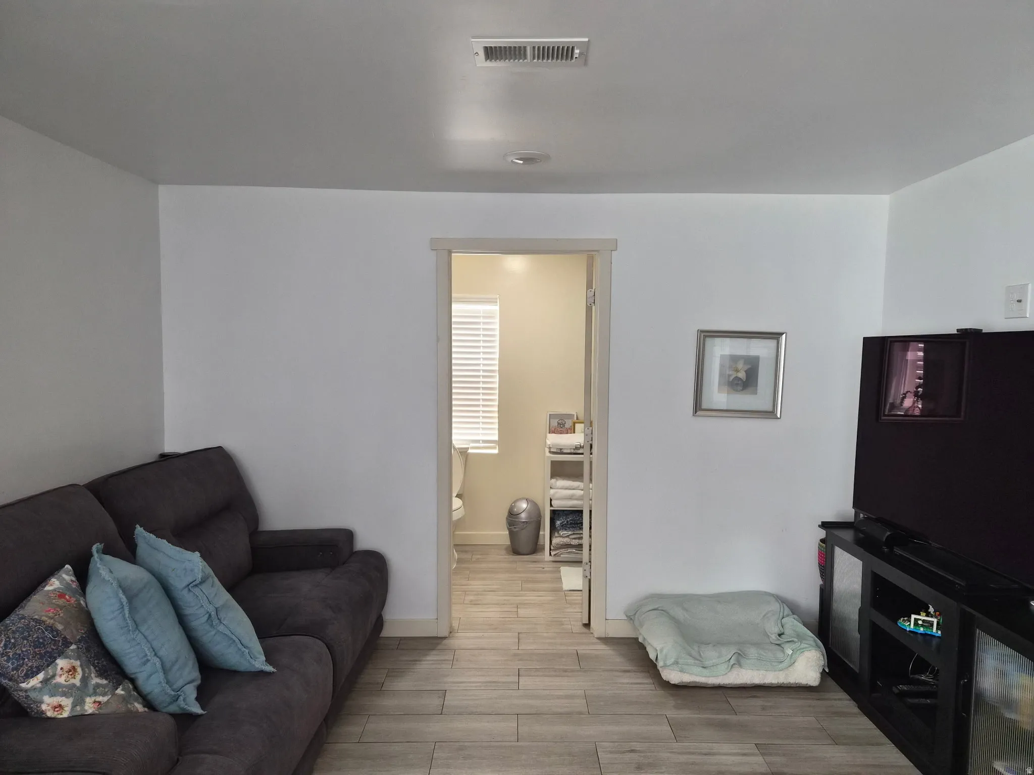 Interior room featuring light wood-finish flooring, white walls, and a recessed ceiling light