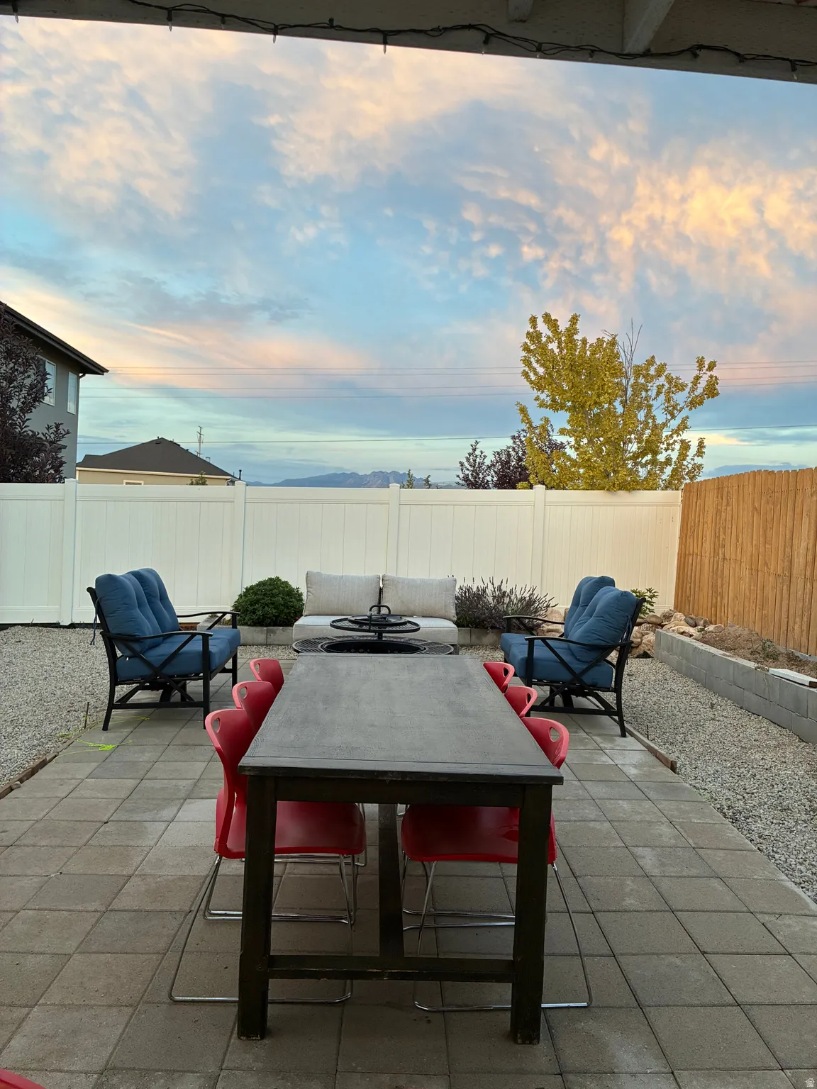 Expansive outdoor patio featuring paver stones and an overhead string light installation