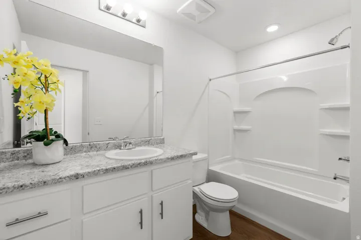 Bathroom featuring a white vanity with a light-toned countertop, undermount sink, and contemporary faucet