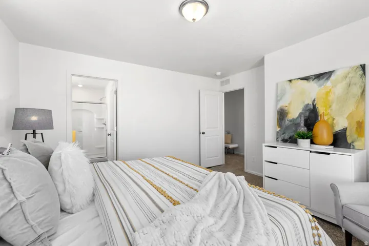Bedroom featuring neutral wall paint, carpet flooring, a ceiling-mounted light fixture, and an en-suite bathroom with a shower
