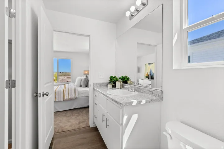 Bathroom vanity with a white countertop and integrated sink, chrome faucet, and under-sink cabinetry