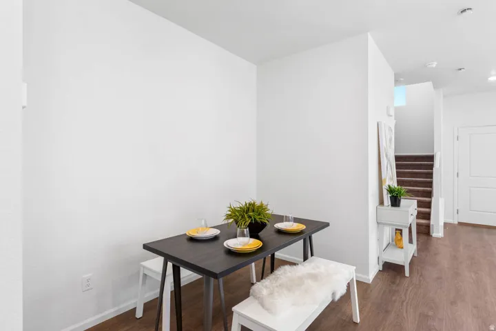 Dining area featuring wood-finish flooring and bright white walls