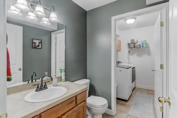Bathroom featuring a wood-finish vanity with a single basin sink and a bronze faucet