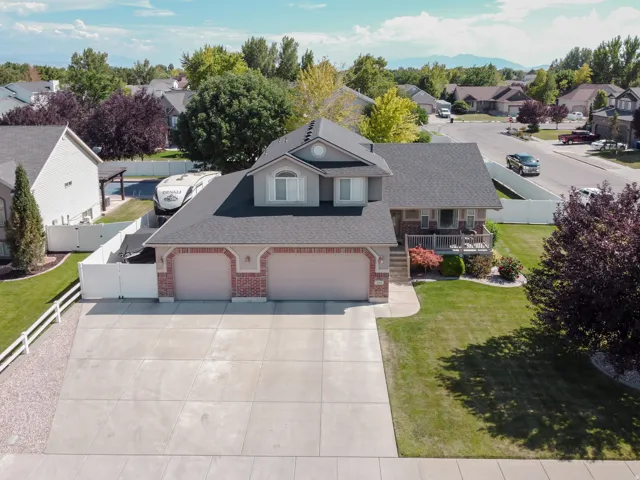 Two-story residence featuring a two-car garage with brick accents and a front porch