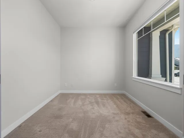 Carpeted room featuring a large window, neutral wall paint, and white trim