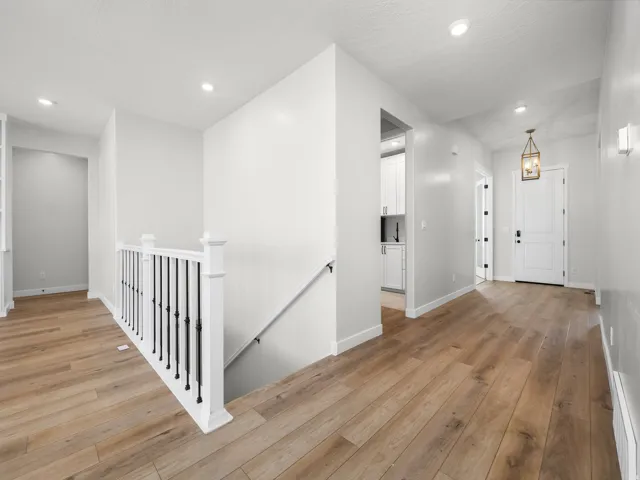 Hardwood-finish flooring extending through the entry and hallway