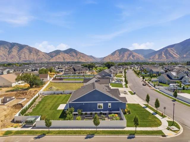 Expansive property featuring a vibrant blue exterior, a large green lawn, and a white perimeter fence