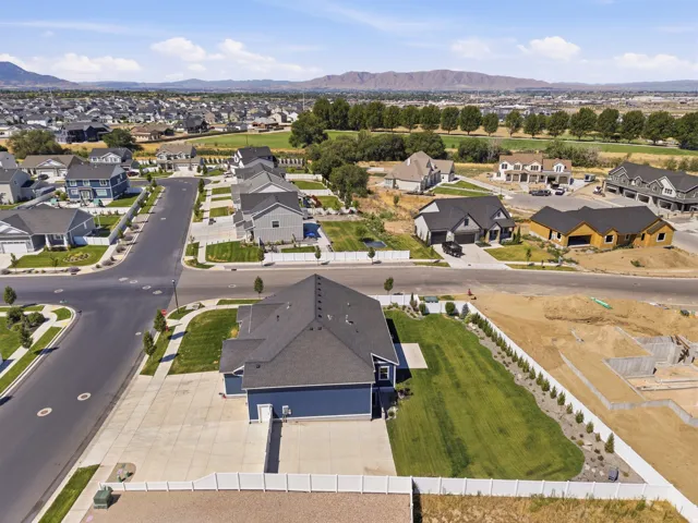 Property featuring a dark blue exterior with a dark gray roof, a white vinyl fence, and a concrete driveway