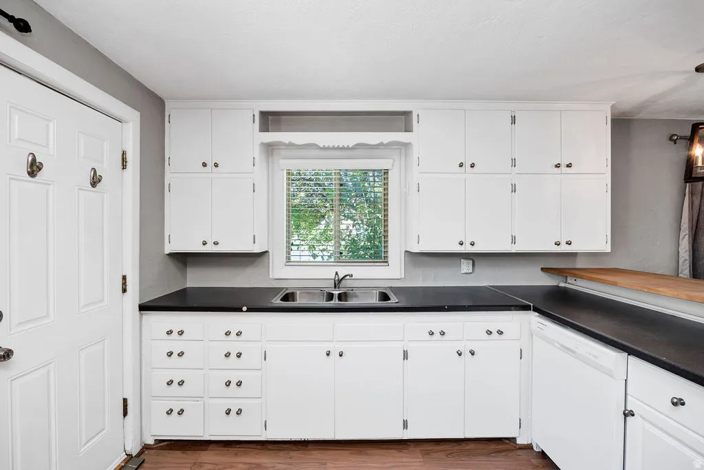 Kitchen featuring white cabinetry and dark countertops