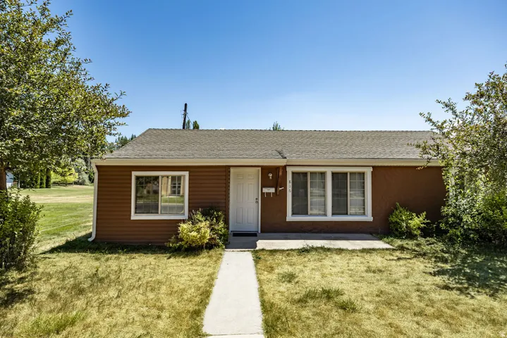 Front exterior featuring a combination of horizontal siding and stucco, a white entry door, and white-trimmed windows