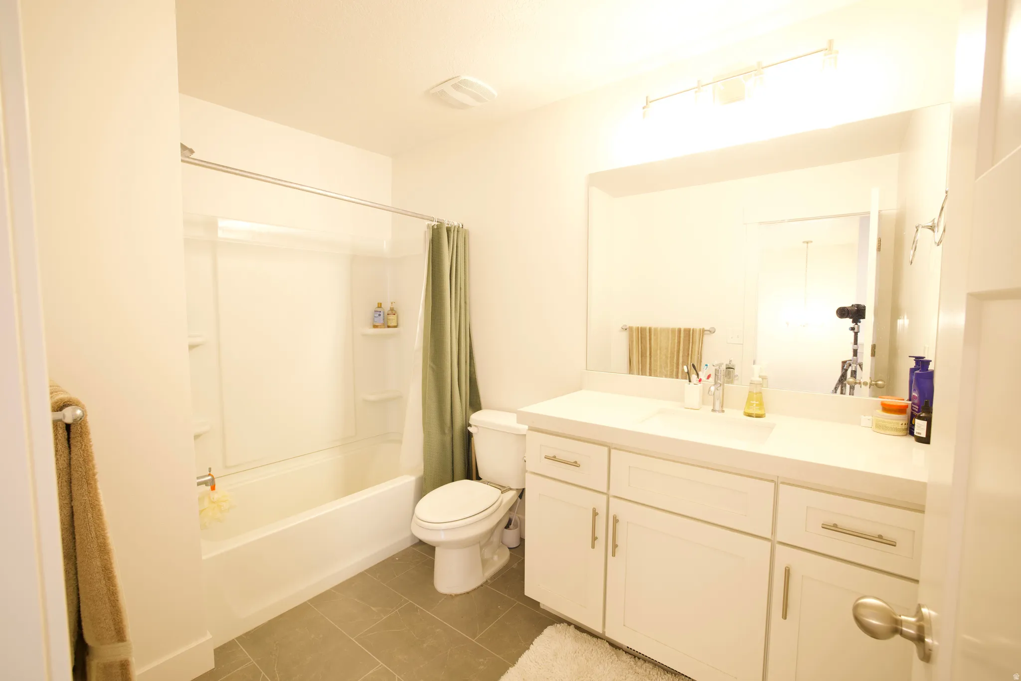 Modern bathroom featuring a white vanity with brushed nickel hardware, a spacious countertop, and an integrated sink