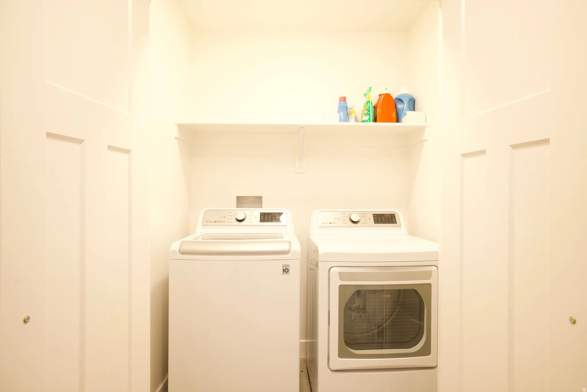 Dedicated laundry area featuring a built-in shelf for storage and a white paneled closet door
