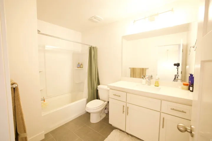 Modern bathroom featuring a white vanity with brushed nickel hardware, a spacious countertop, and an integrated sink