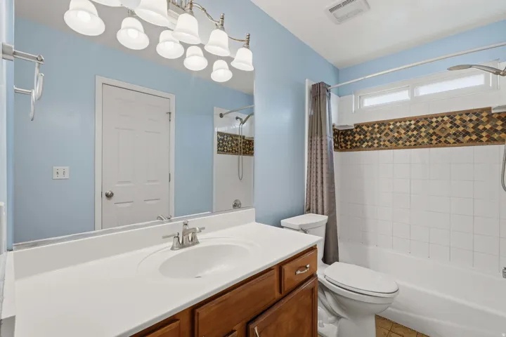 Bathroom featuring a white vanity with an integrated sink, wood-finish cabinetry, and a chrome faucet
