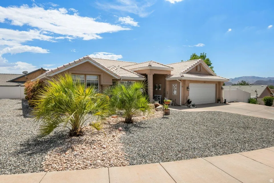Single-story residence featuring a tile roof, stucco exterior, and an attached two-car garage