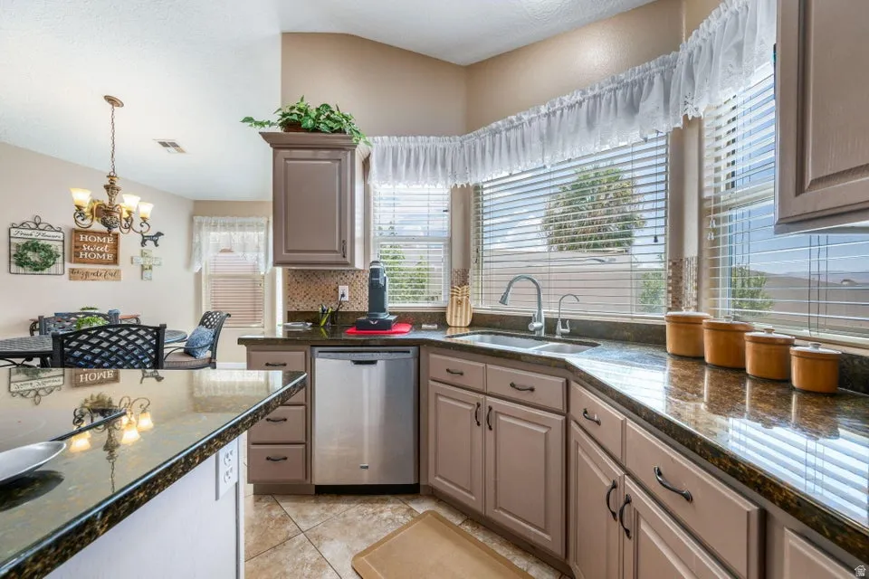 Kitchen featuring granite-style countertops, stainless steel appliances, and a mosaic tile backsplash