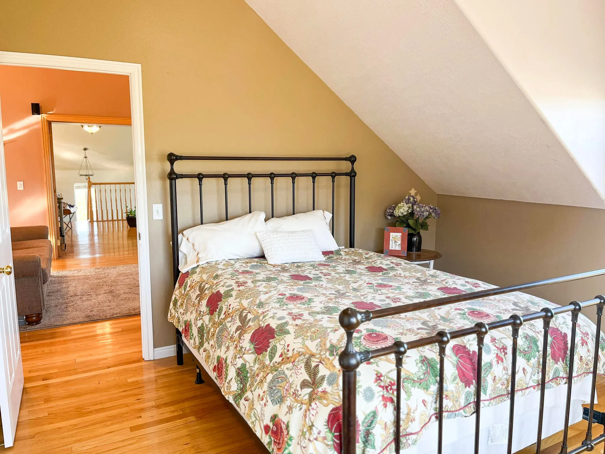 Bedroom featuring wood-finish flooring and an angled ceiling line
