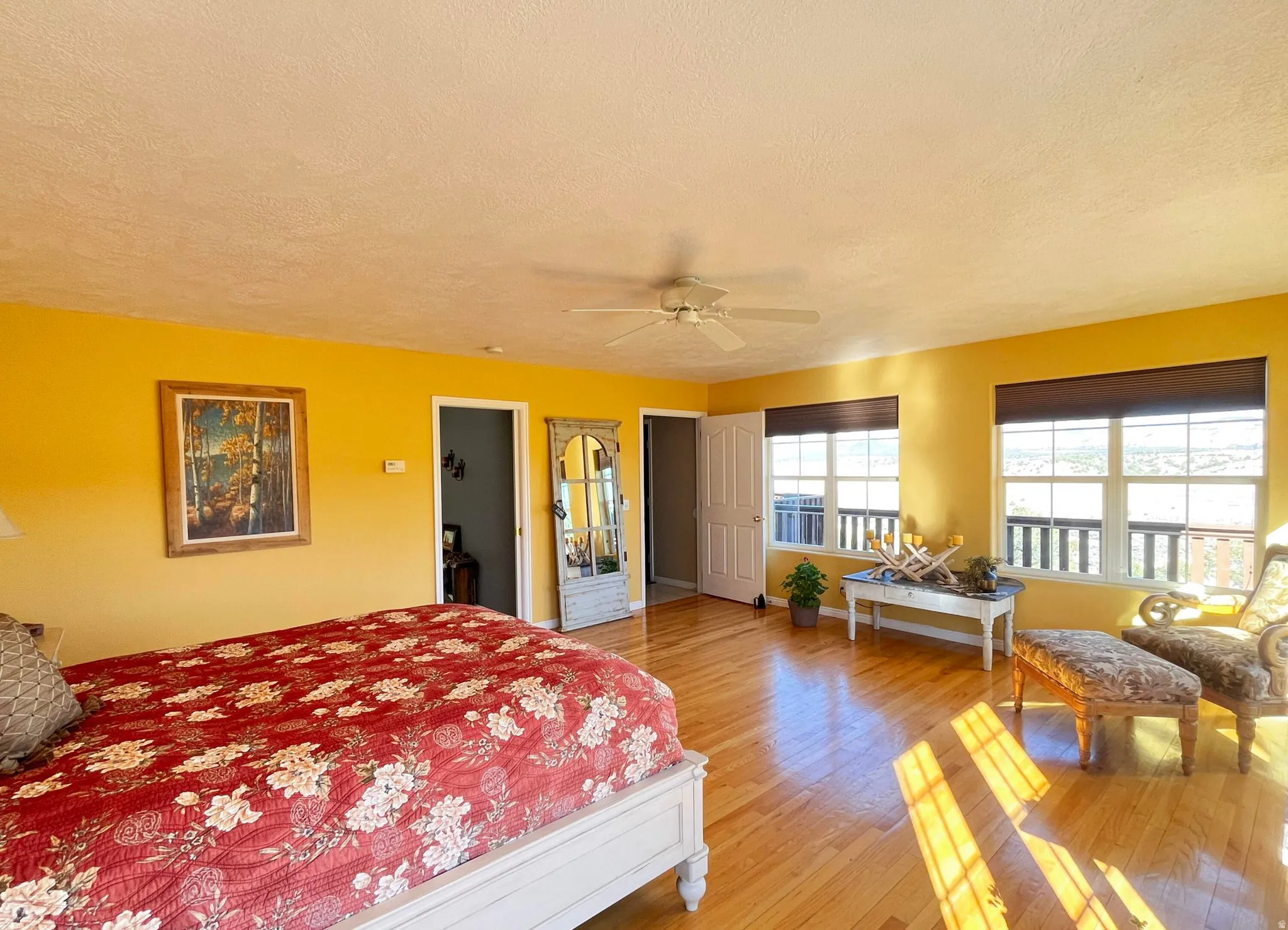 Spacious room featuring wood-finish flooring and a ceiling fan
