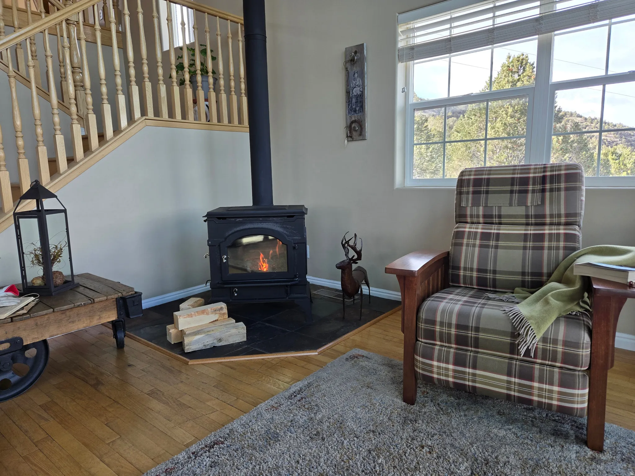 Freestanding wood stove with a tiled hearth, bordered by light wood-finish flooring