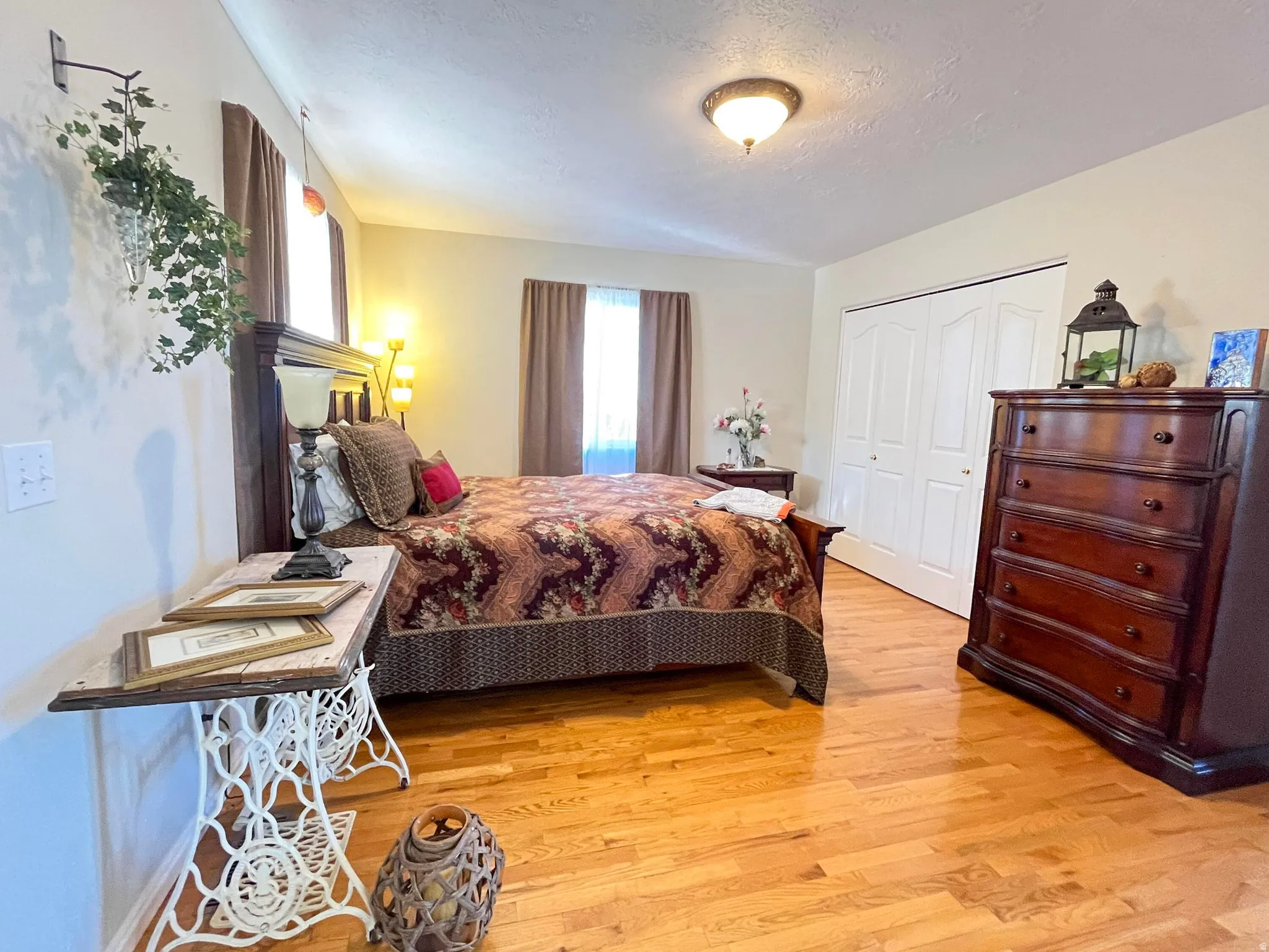 Bedroom featuring lustrous wood-finish flooring, light-colored walls, and a ceiling-mounted light fixture