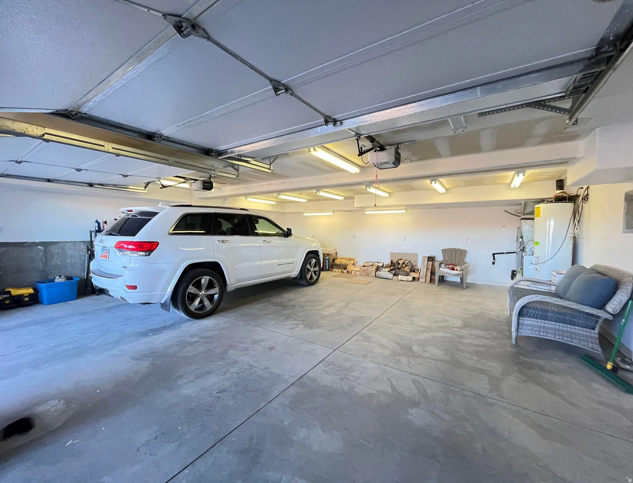 Spacious two-car garage featuring a concrete floor and white walls