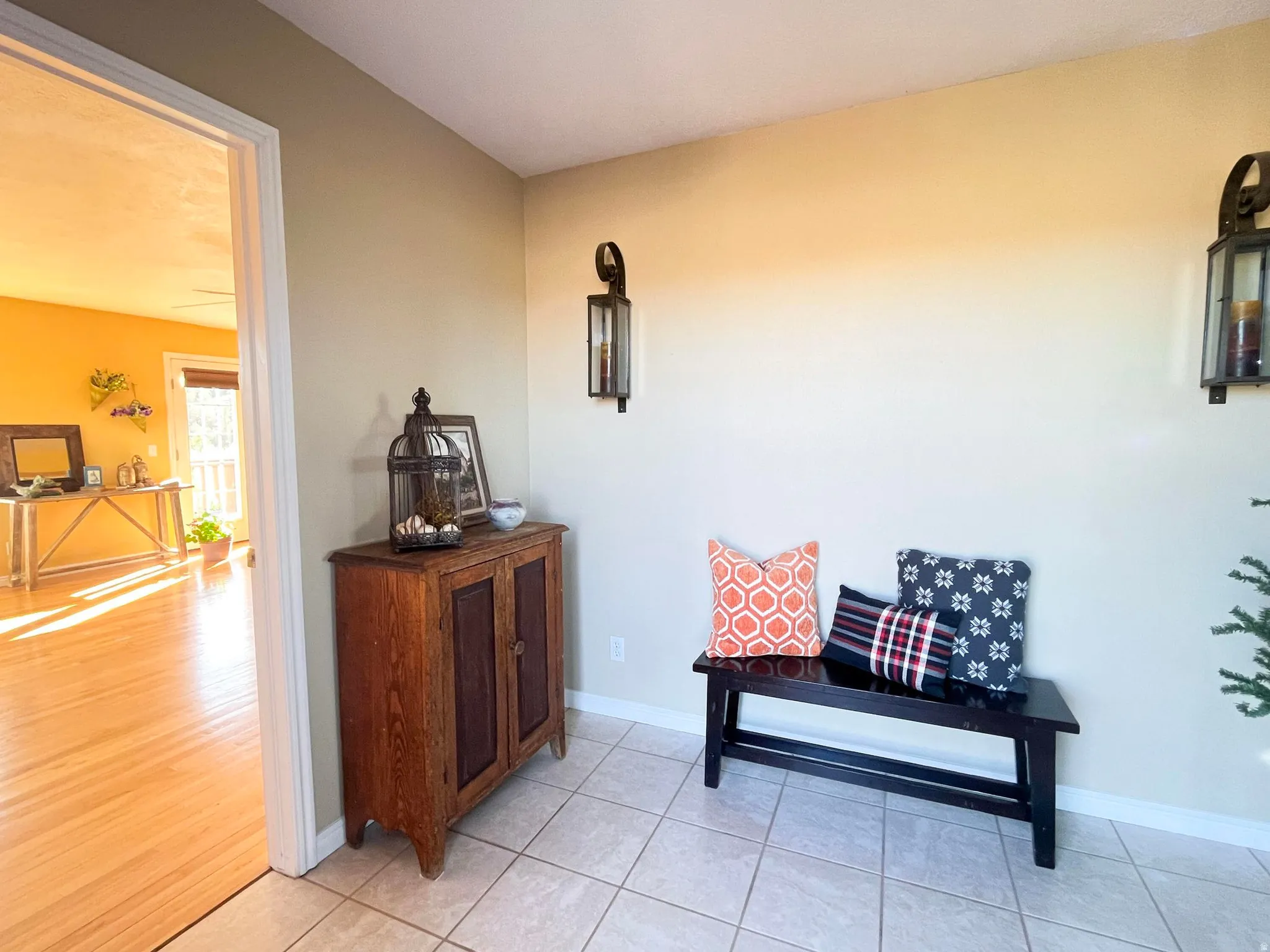 Tiled entry with neutral wall tones and decorative wall sconces