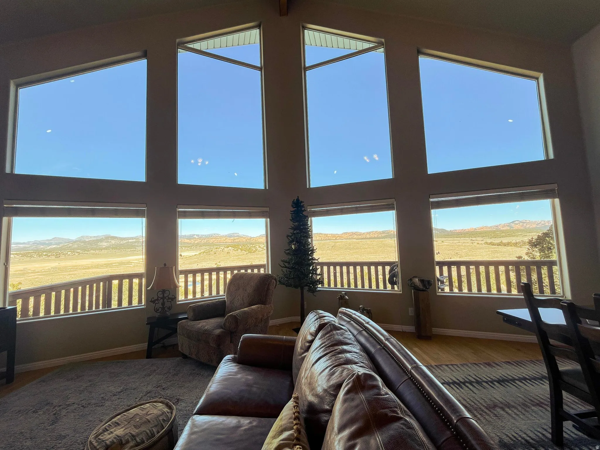 Vaulted great room with expansive window wall showcasing distant mountain and desert scenery
