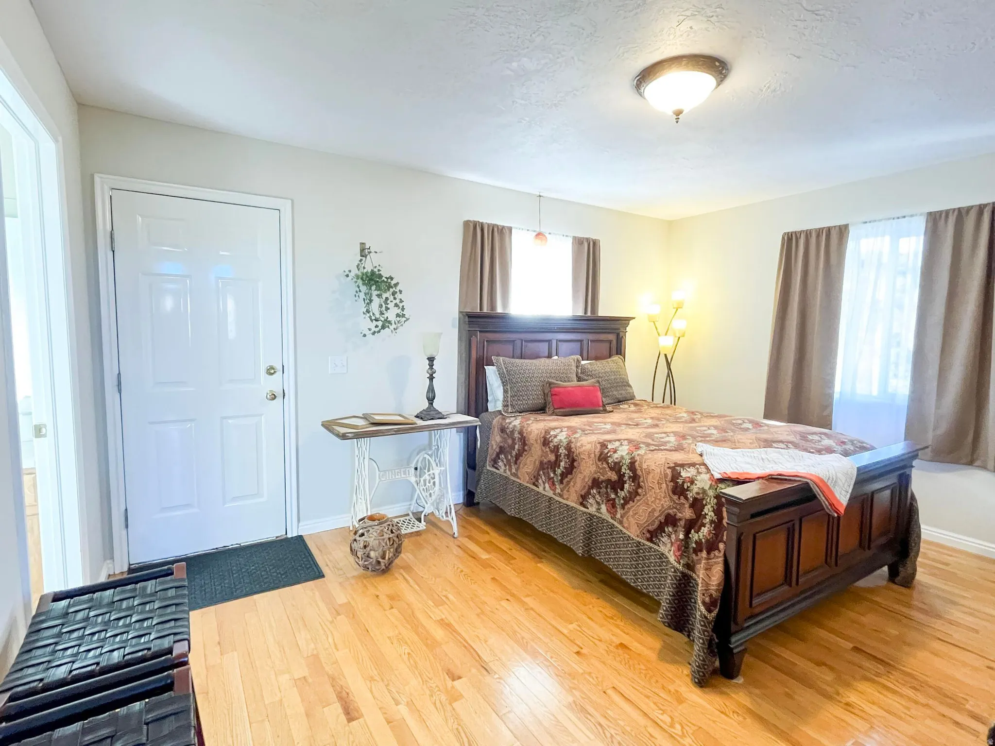 Light wood-finish flooring complements neutral wall tones and a white paneled door