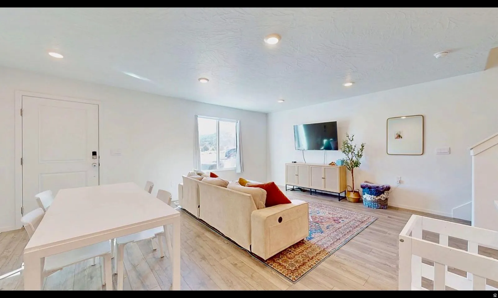 Open-concept living space with light wood-finish flooring