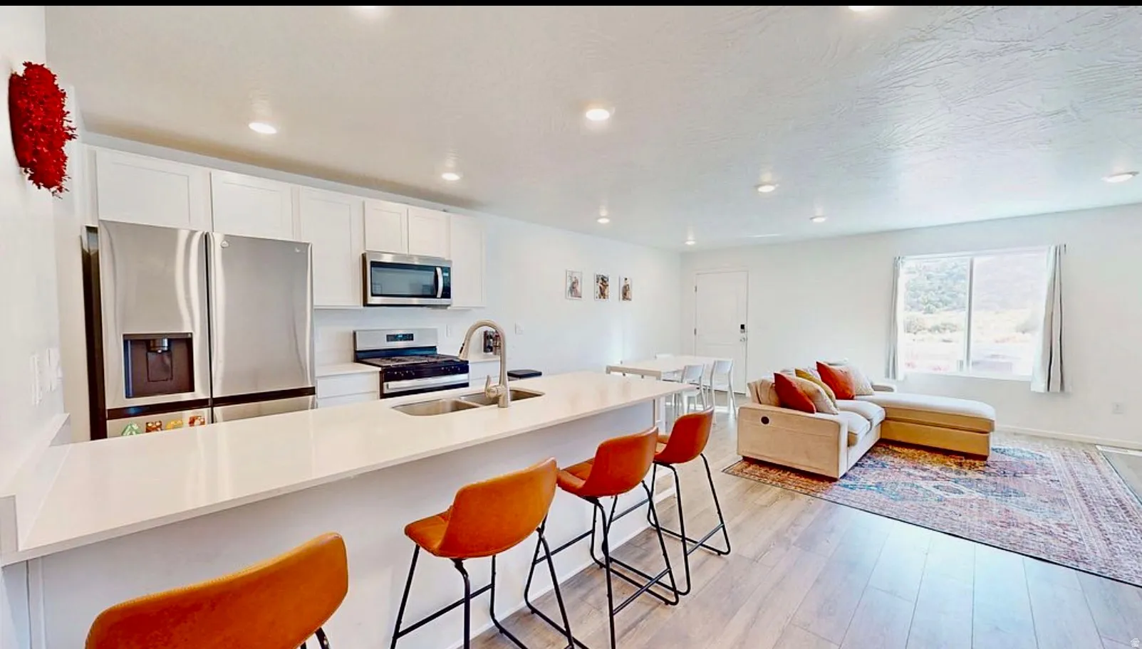 Open-concept living space with light-tone wood-finish flooring