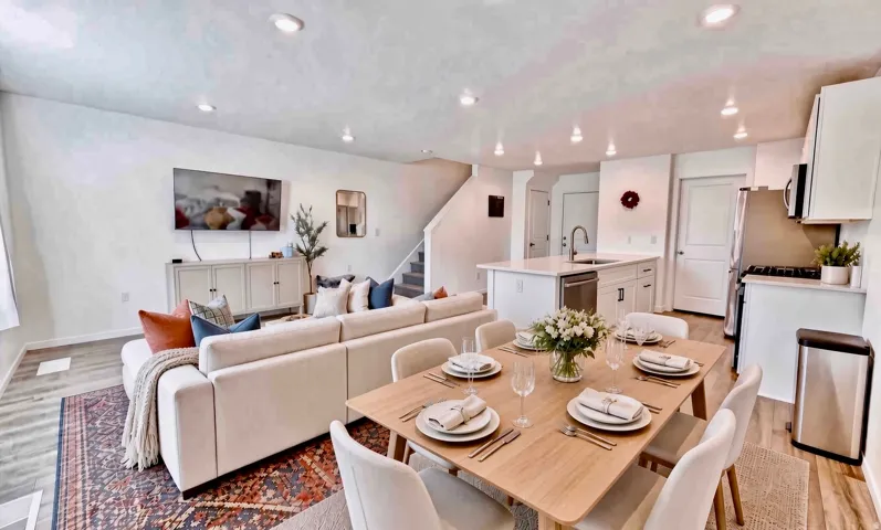 Open-concept living space featuring wood-finish flooring, recessed lighting, and a kitchen island with sink